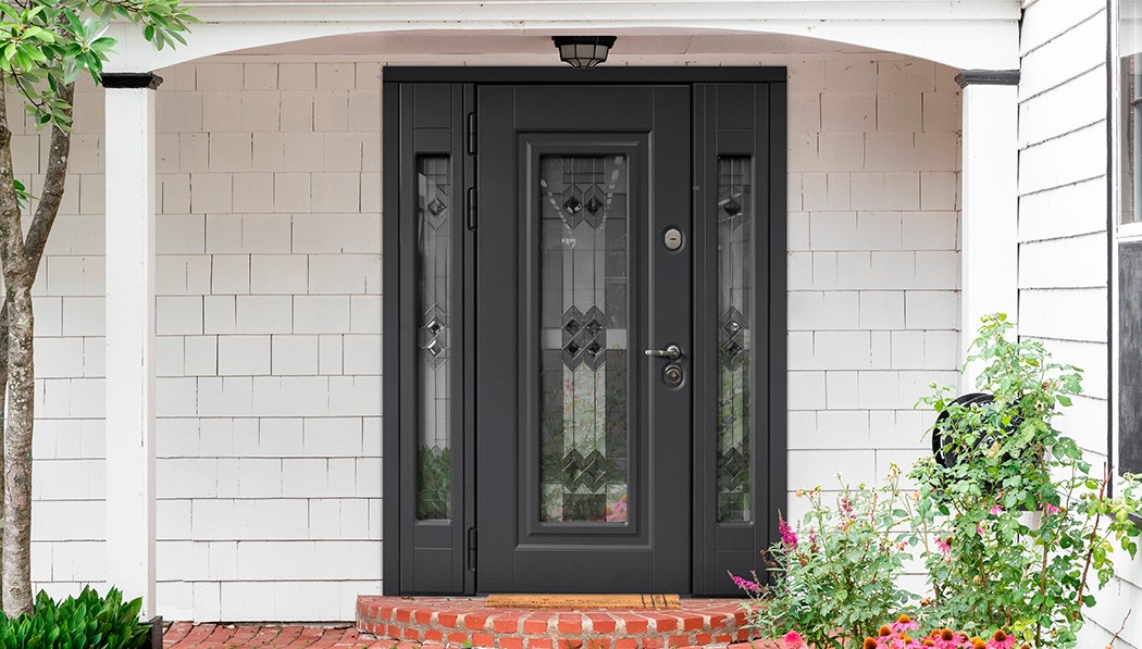 Входная дверь с витражом темного цвета, установлена в широкий проём с тремя монохромными вставками.