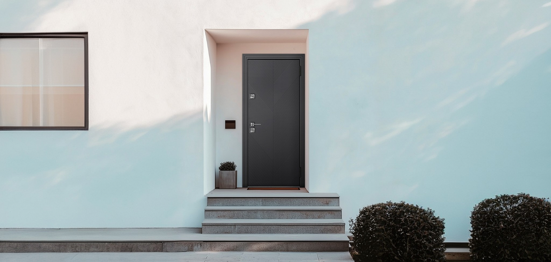 Многостворчатые входные двери для частного дома в современном фасаде с минималистичным дизайном.