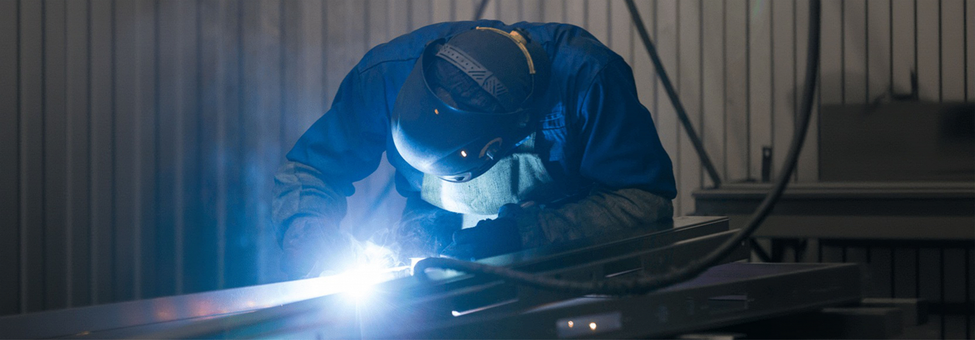 Изготовление металлических дверей — ручная сварка конструкций в производственном цеху.