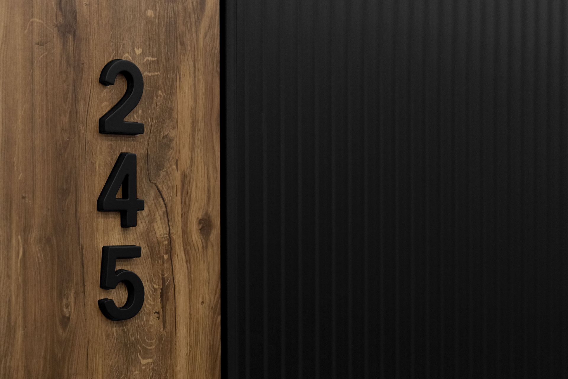 Цифра на дверь — стильное вертикальное обозначение номера квартиры в черном оформлении.