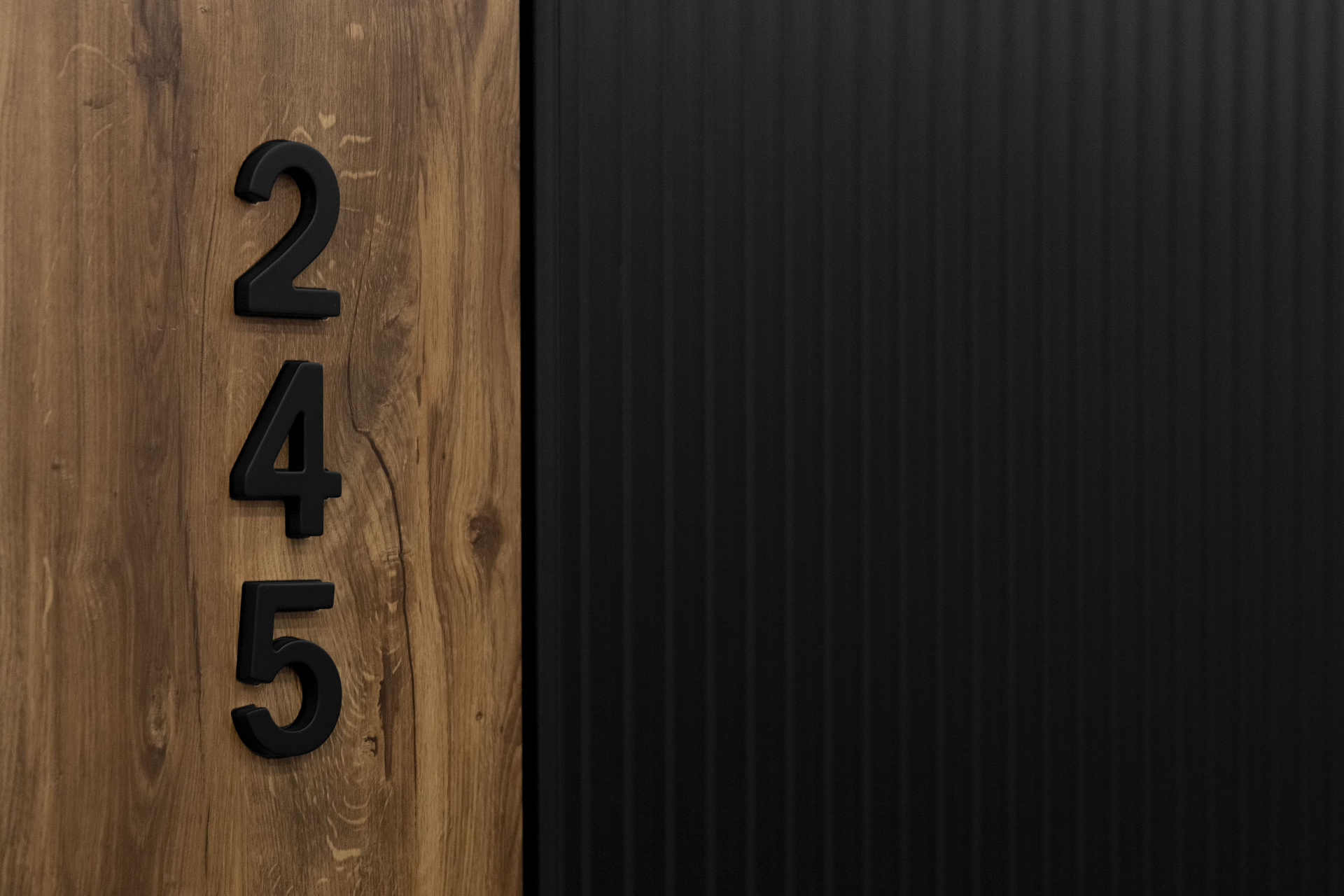 Цифра на дверь — стильное вертикальное обозначение номера квартиры в черном оформлении.