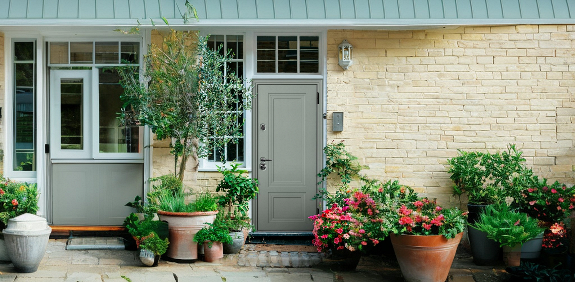 Непромерзающие входные двери в частный дом из оцинкованной стали рядом с цветочным декором.